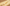 Gold droplet on a wooden surface with a soft focus background